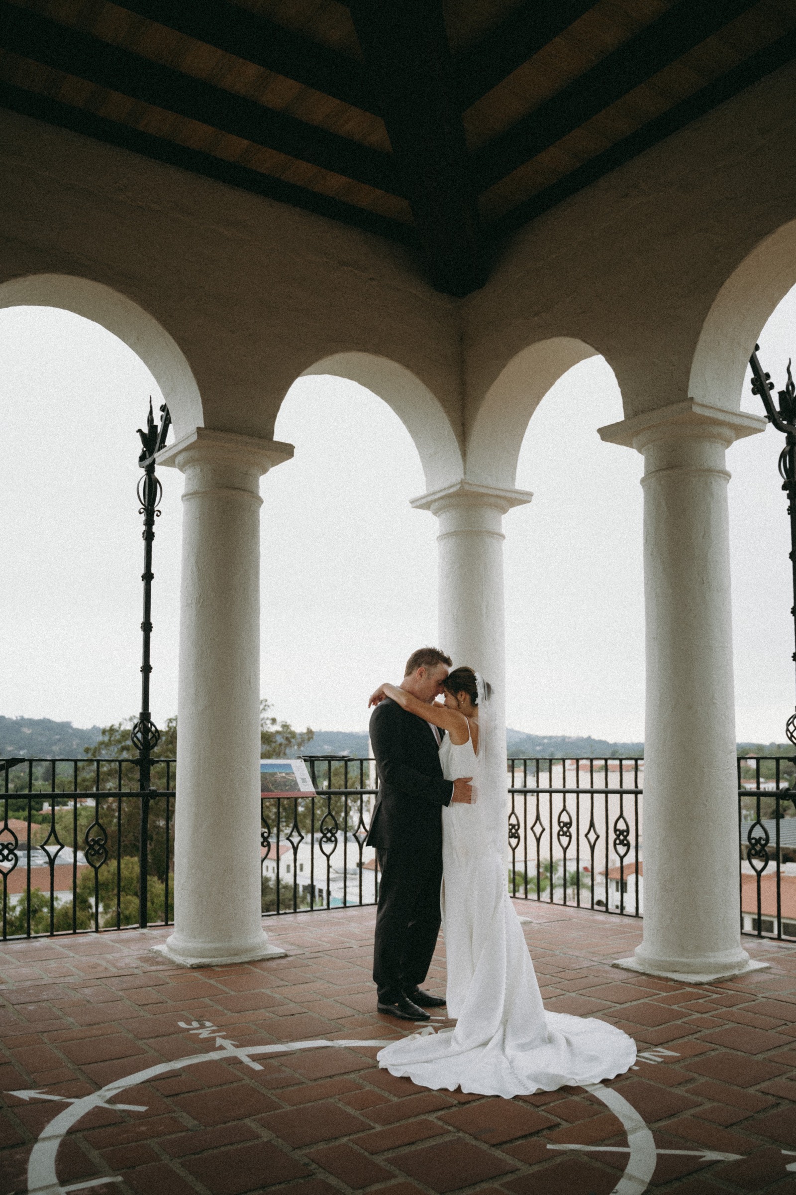 Lucy and Jon embracing beneath the courthouse arches